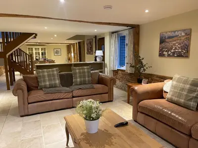 a living room with two couches and a table at Stunning converted barn - Brand sleeps 8 in Sutton