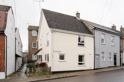 a white house with a black roof on a street at La Casa Bianca in Bury Saint Edmunds