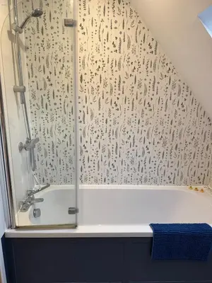 a bathroom with a shower and a bath tub at Cosy Flint Cottage in Thurston