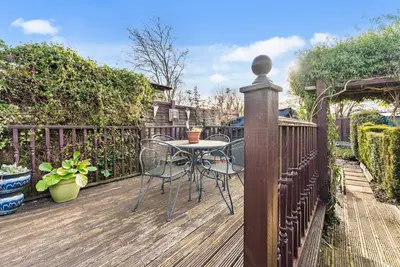 a wooden deck with a table and chairs on it at Abbey House- Character filled 1 bed- sleeps 4 in Bury Saint Edmunds