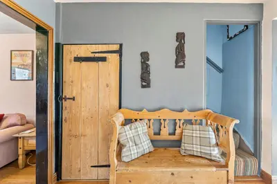 a room with a wooden bench with pillows on it at Abbey House- Character filled 1 bed- sleeps 4 in Bury Saint Edmunds