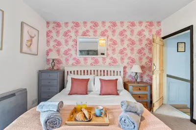 a bedroom with a bed with a tray of food on it at Abbey House- Character filled 1 bed- sleeps 4 in Bury Saint Edmunds