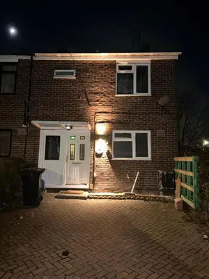 a brick house with a white door at night at Serene Guest Retreat in Basildon Comfort and Convenience Await in Basildon