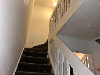 a staircase in a house with black carpet at Charming 4-Bedroom House Rental in Basildon, UK in Basildon