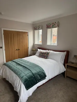 a bedroom with a large bed and two windows at Half Moon Nest - Refurbished throughout for 2026 in Diss