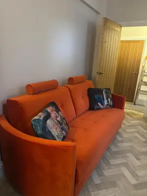 an orange couch sitting in a living room at Half Moon Nest - Refurbished throughout for 2026 in Diss