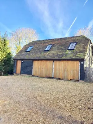 a large wooden barn with four windows on it at Idyllic rural retreat, easy access to Cambridge