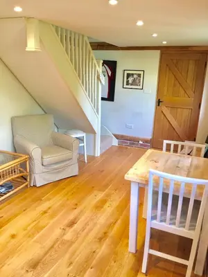 a living room with a wooden table and stairs at Idyllic rural retreat, easy access to Cambridge