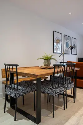 a dining room table with two chairs and a lamp at Station View - Modern Flat Near Centre & Station in Cambridge