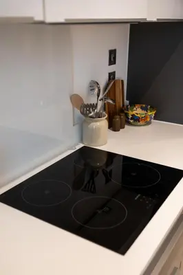a black stove top in a white kitchen at Station View - Modern Flat Near Centre & Station in Cambridge