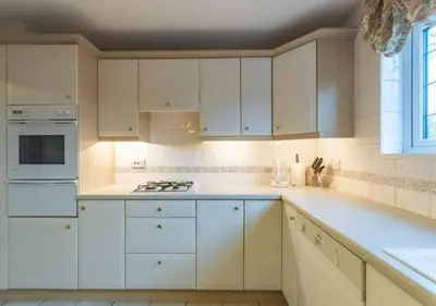 a kitchen with white cabinets and a stove top oven at Tudor Style Seafront Home Sea Views Shoebury - Pass the Keys in Southend-on-Sea