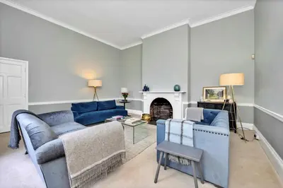 a living room with two blue couches and a fireplace at Finest Retreats - Clavering Hall in Saffron Walden