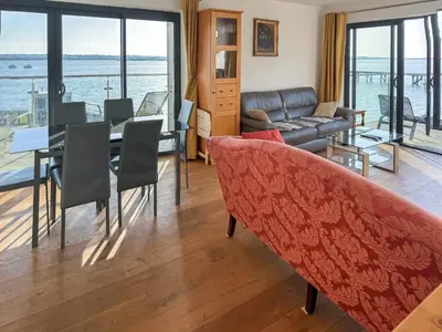 a living room with a couch and a table with chairs at Admiralty Lodge in Shotley Gate