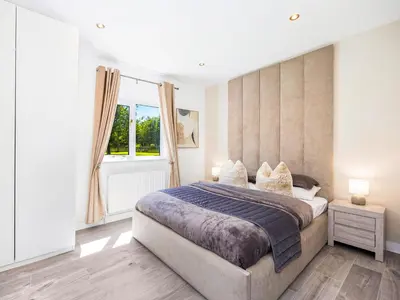 a bedroom with a large bed and a window at Essex Barn House - Uk48354 in Romford