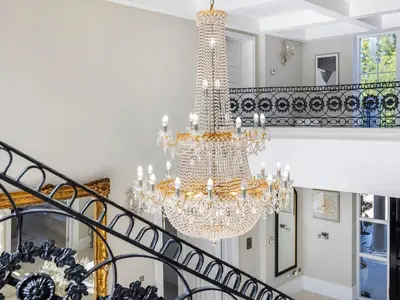a chandelier hangs from a staircase in a house at The Essex Mansion - Uk48355 in Romford