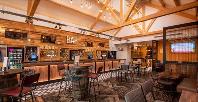 a restaurant with a bar with chairs and tables at M&B Holiday Home and Caravan in Saint Osyth