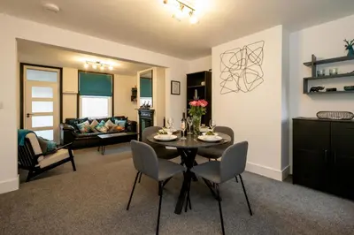 a dining room and living room with a table and chairs at 21 Urban Road, sleeps 5 guests, Leiston, near Sizewell, Managed by Aldeburgh Coastal Cottages in Leiston