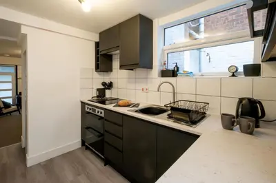 a kitchen with black cabinets and a sink and a window at 21 Urban Road, sleeps 5 guests, Leiston, near Sizewell, Managed by Aldeburgh Coastal Cottages in Leiston