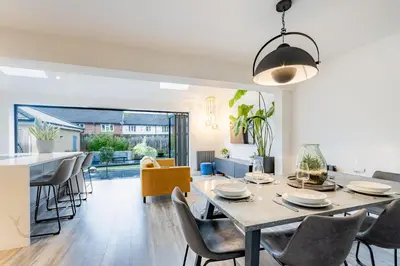 a dining room and living room with a table and chairs at Comfortable 3 bedroom Home Chelmsford Sleeps 5 - Pass the Keys in Chelmsford