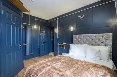 a bedroom with blue walls and a bed with white pillows at Cozy Studio Apartment in Southend-on-Sea in Southend-on-Sea