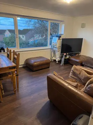a living room with a couch and a flat screen tv at House in Colchester with parking in Colchester