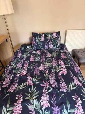 a bed with a purple bedspread with flowers on it at NEW Gorgeous Boutique Country Getaway in Tuddenham