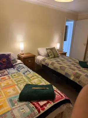 a bedroom with two beds and two tables and lamps at The Wright One Bedroom Place To Stay in Kingsgate