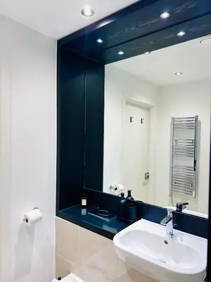 a bathroom with a sink and a large mirror at Bright Corner Apartment by Cambridge Station with Free Allocated Underground Parking & Flexible Beds in Cambridge