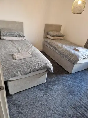 a bedroom with two beds and a blue carpet at Bright Corner Apartment by Cambridge Station with Free Allocated Underground Parking & Flexible Beds in Cambridge