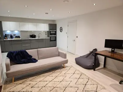 a living room with a couch and a kitchen at Bright Corner Apartment by Cambridge Station with Free Allocated Underground Parking & Flexible Beds in Cambridge