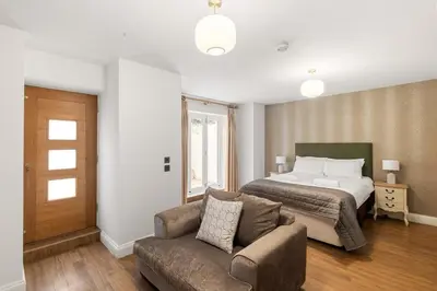 a bedroom with a bed and a couch and a bed at Modern 3BR Basement Flat with Outdoor Terrace in Southend-on-Sea