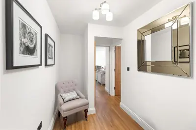 a living room with a chair and a mirror at Modern 3BR Basement Flat with Outdoor Terrace in Southend-on-Sea