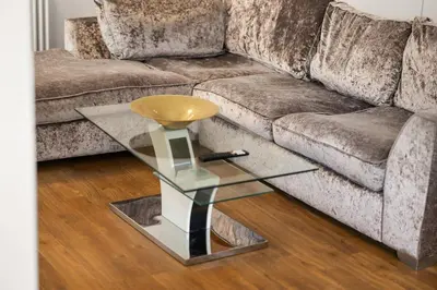 a glass coffee table in front of a couch at Modern 3BR Basement Flat with Outdoor Terrace in Southend-on-Sea