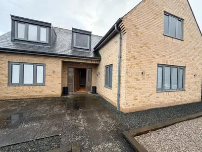 a brick house with a driveway in front of it at Turnpike Red Lodge in Bury Saint Edmunds