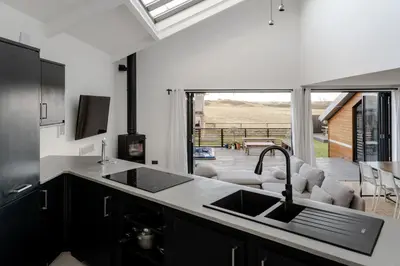 a kitchen with a sink and a view of a patio at Luxurious Retreat with Cinema Lounge in Ely