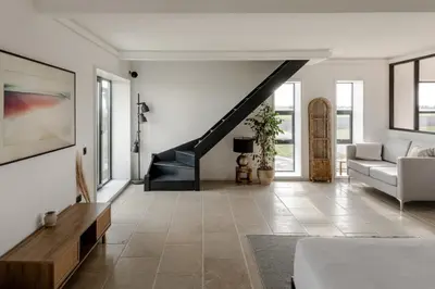 a living room with a couch and a staircase at Luxurious Retreat with Cinema Lounge in Ely