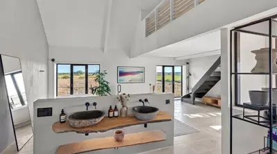a bathroom with two sinks in a room with windows at Luxurious Retreat with Cinema Lounge in Ely