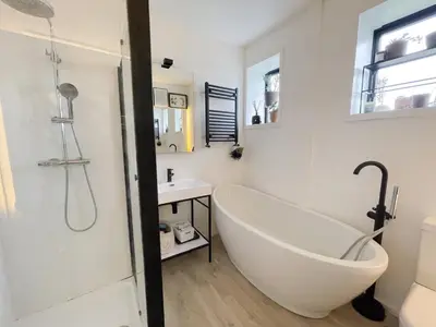 a white bathroom with a tub and a sink at Luxurious Retreat with Cinema Lounge in Ely
