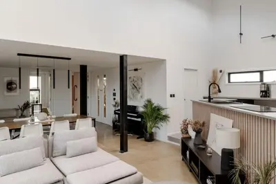 a living room with white furniture and a kitchen at Luxurious Retreat with Cinema Lounge in Ely