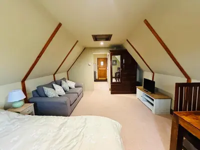 a living room with a couch and a tv at The Barn at Catley Cross House in Little Maplestead