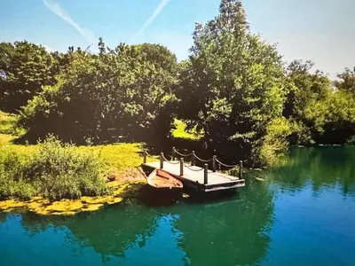 a small boat in the middle of a lake at The Barn at Catley Cross House in Little Maplestead