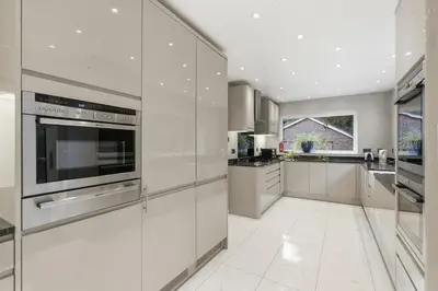 a large white kitchen with stainless steel appliances at Luxury 5 Bedroom with Pool & Games Room in Potter Street