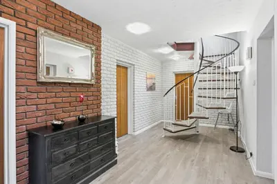 a living room with a brick wall and a staircase at Luxury 5 Bedroom with Pool & Games Room in Potter Street