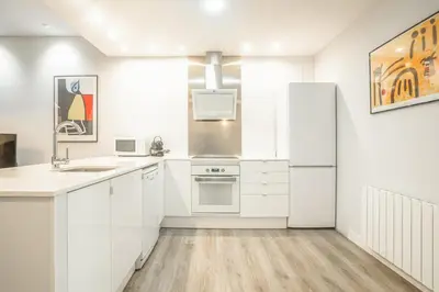 a kitchen with white cabinets and a refrigerator at Apartment Clarke in Cambridge