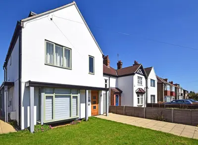 a white house with a garage at Beautiful flat in a perfect location in Cambridge
