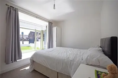 a bedroom with a bed and a large window at Beautiful flat in a perfect location in Cambridge