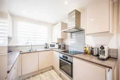 a kitchen with white cabinets and a sink at Modern 2-Bed Home in Leiston in Leiston