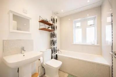 a bathroom with a sink and a toilet and a bath tub at Modern 2-Bed Home in Leiston in Leiston