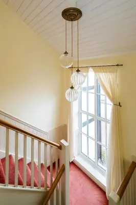 a room with a staircase and a window at Hermitage House, Thorpeness - sleeps 12 - Large Thorpeness house on the banks of Thorpness Meare - a boating lake - Close to Thorpeness beach, Golf Club and Thorpeness Country Club - Aldeburgh Coastal Cottages in Thorpeness