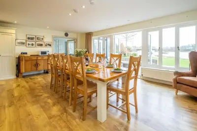 a kitchen and dining room with a table and chairs at Hermitage House, Thorpeness - sleeps 12 - Large Thorpeness house on the banks of Thorpness Meare - a boating lake - Close to Thorpeness beach, Golf Club and Thorpeness Country Club - Aldeburgh Coastal Cottages in Thorpeness